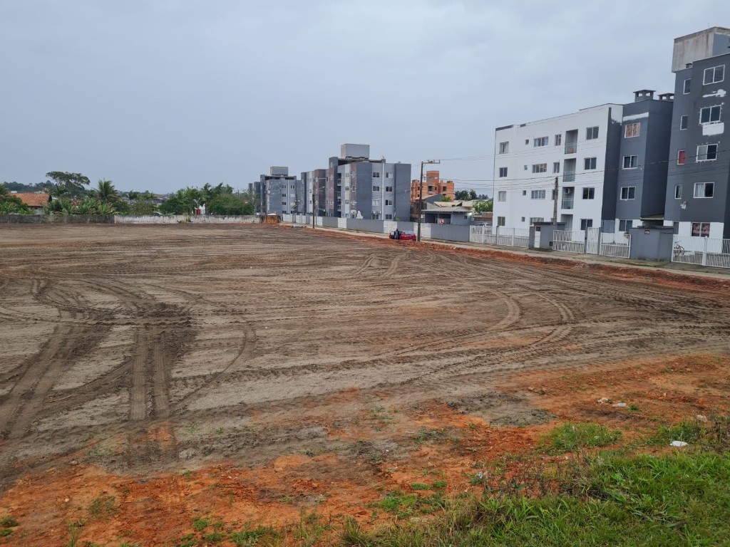 Terraplenagem em condomínio residencial com prédios ao fundo