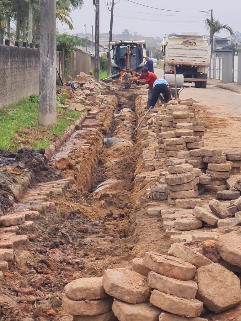 Execução de drenagem pluvial em rua com tubulação instalada